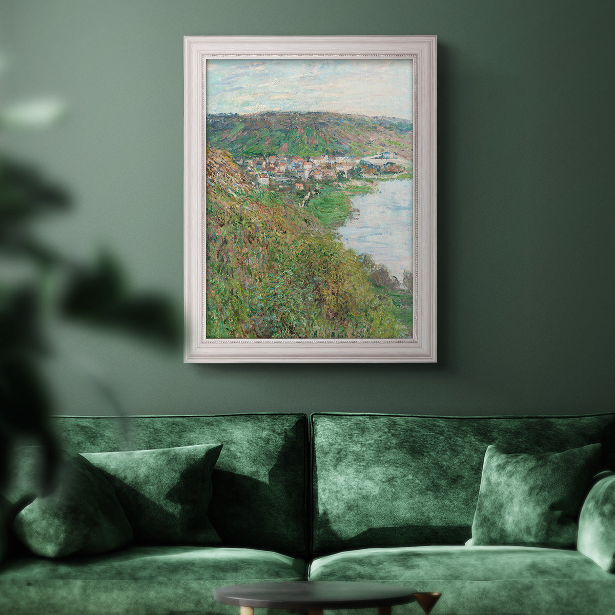 Impressionist landscape view of Vétheuil by Claude Monet in an ornate weathered white frame displayed in a dark-toned interior setting.