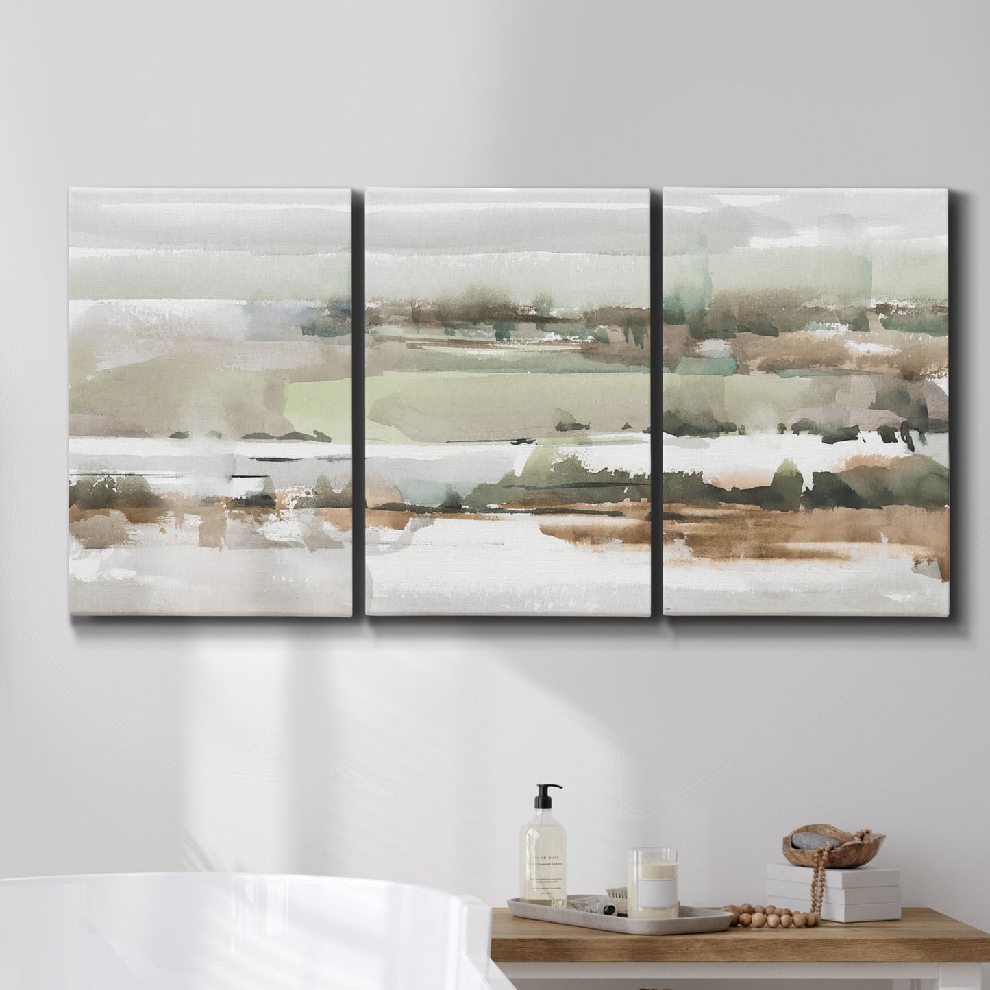 Three-panel canvas wall art featuring layered turquoise and earth tones abstract, displayed in a bathroom above a bathtub.