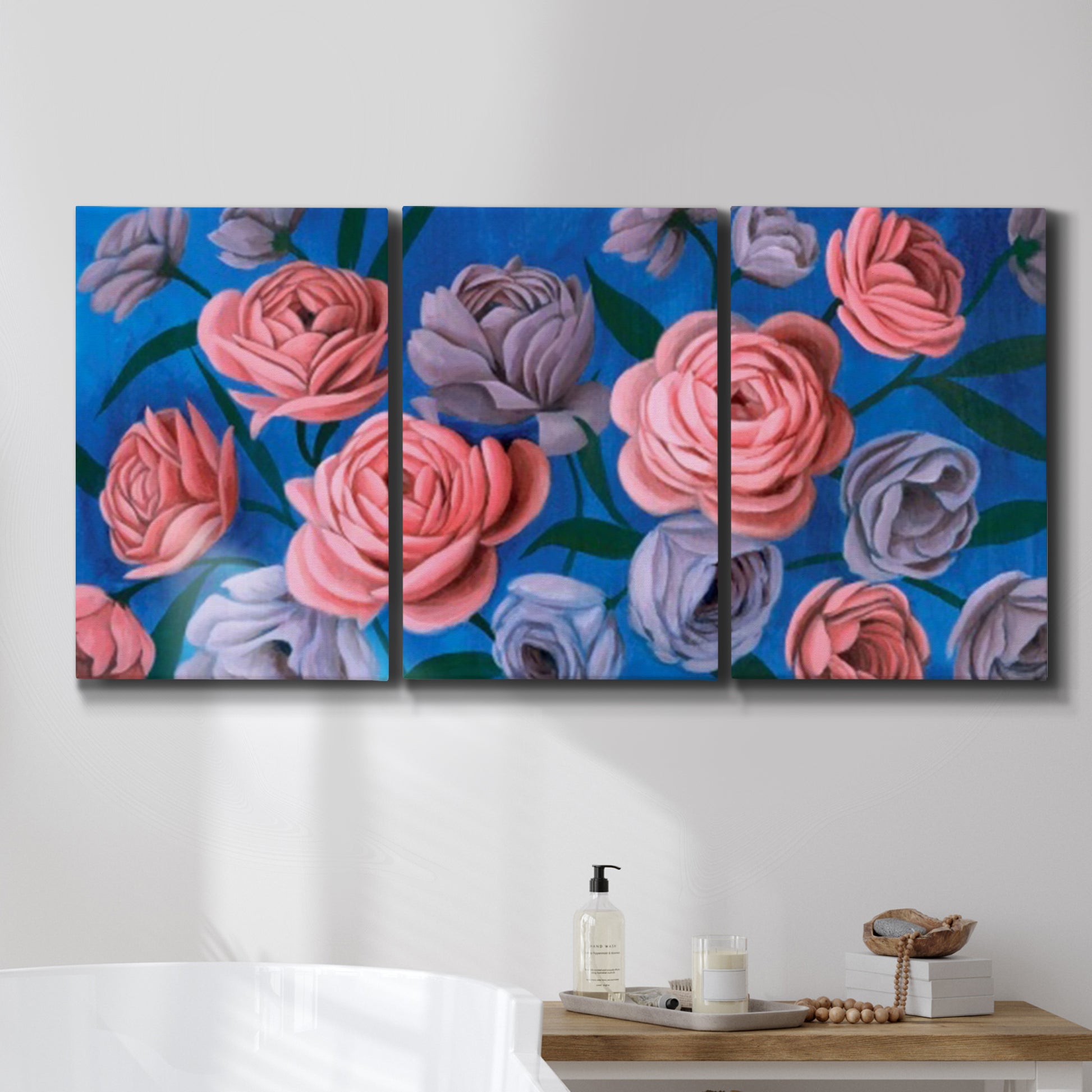 Three-panel canvas wall art featuring layered botanical petal abstractions, displayed in a bathroom above a bathtub.