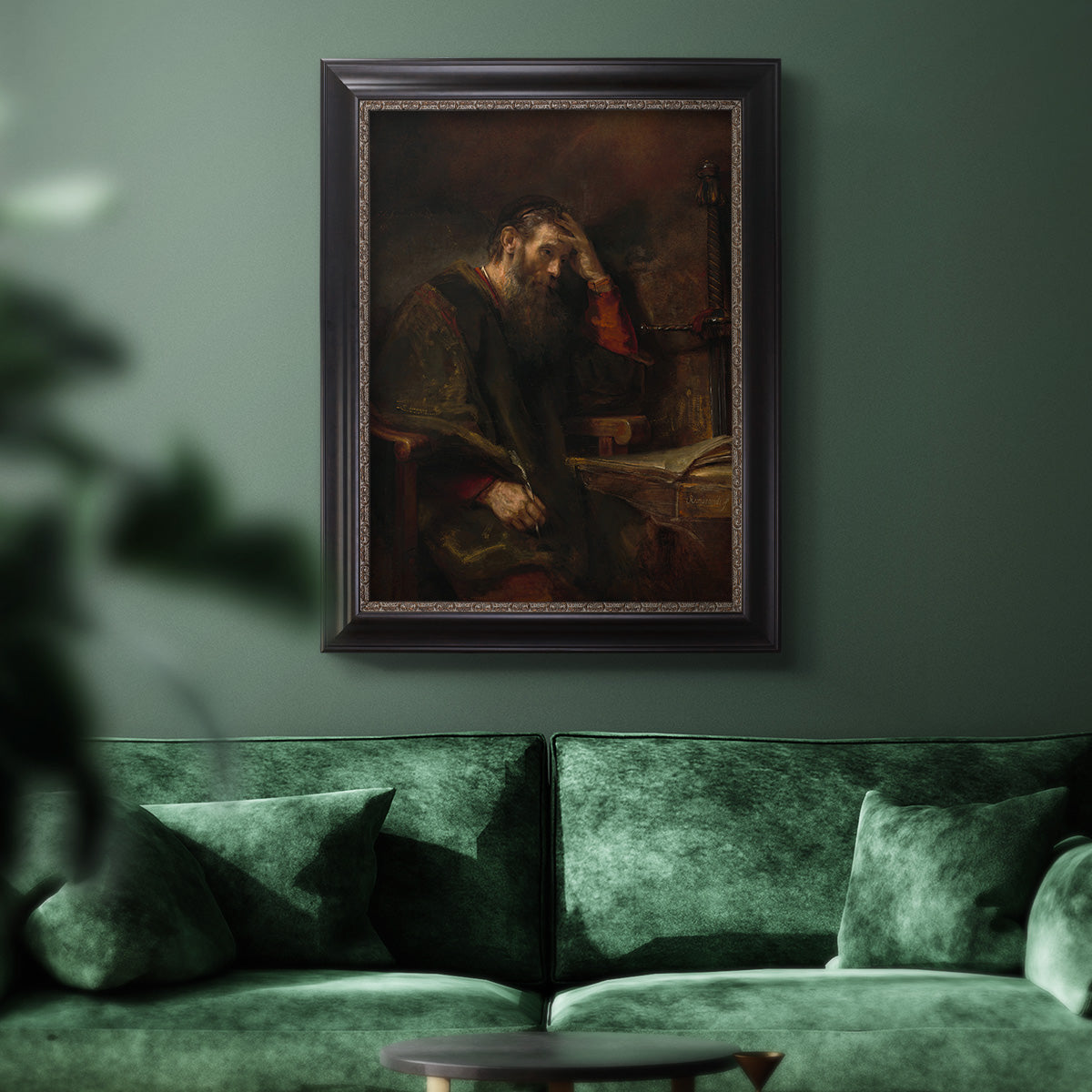 Classical religious portrait of Paul the Apostle by Rembrandt van Rijn in an ornate black frame with gilded inner detail displayed in a dark-toned interior setting.