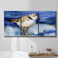 Three-panel canvas wall art featuring shorebirds standing in shallow water, displayed in a bathroom above a bathtub.