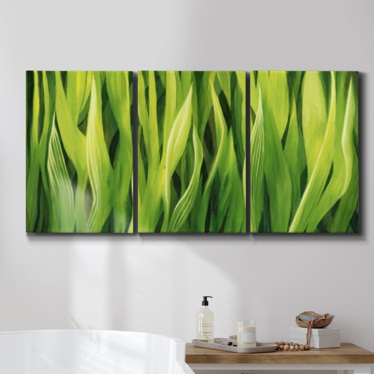 Three-panel canvas wall art featuring close view of tall green grass blades, displayed in a bathroom above a bathtub.