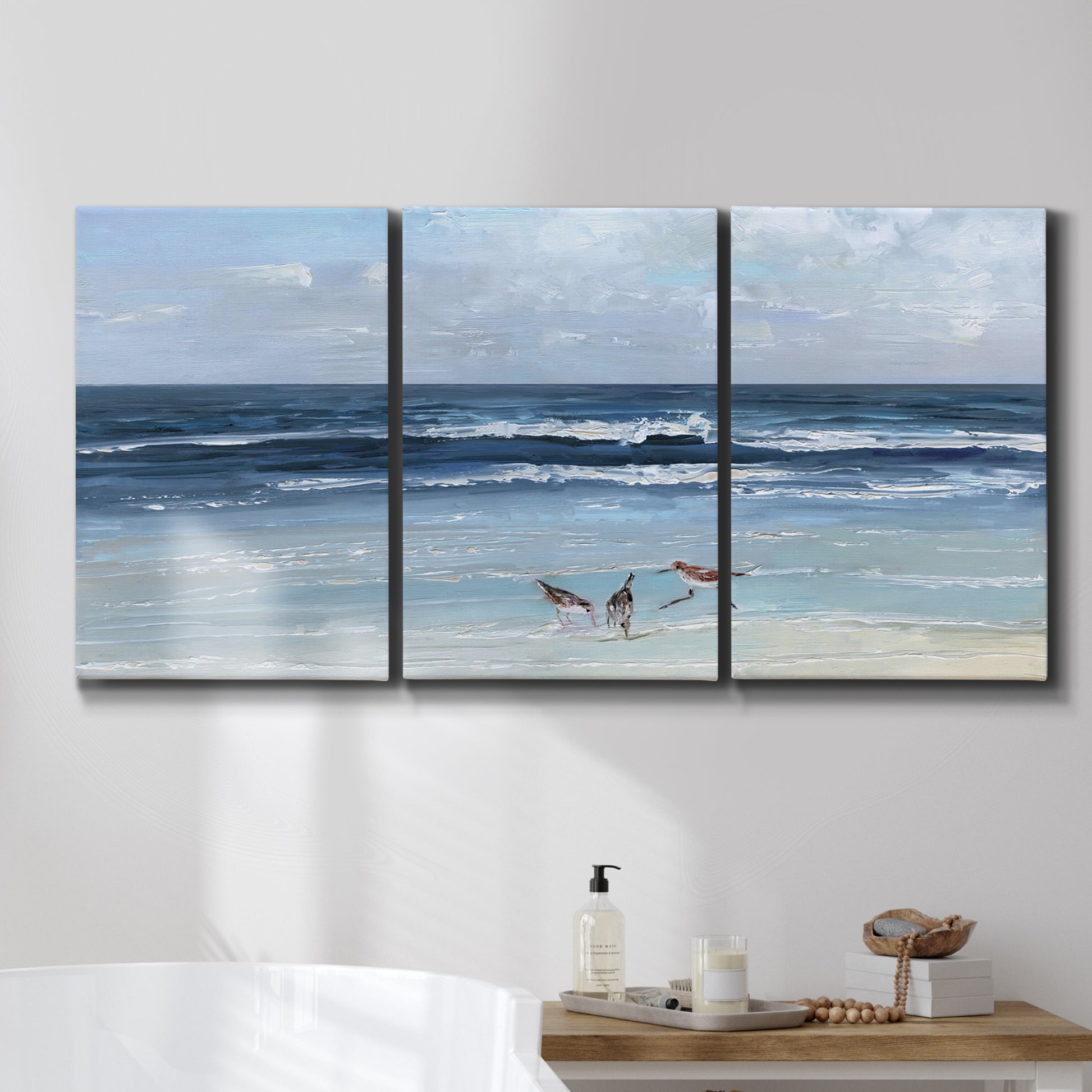 Three-panel canvas wall art featuring loose farmhouse style floral painting, displayed in a bathroom above a bathtub.