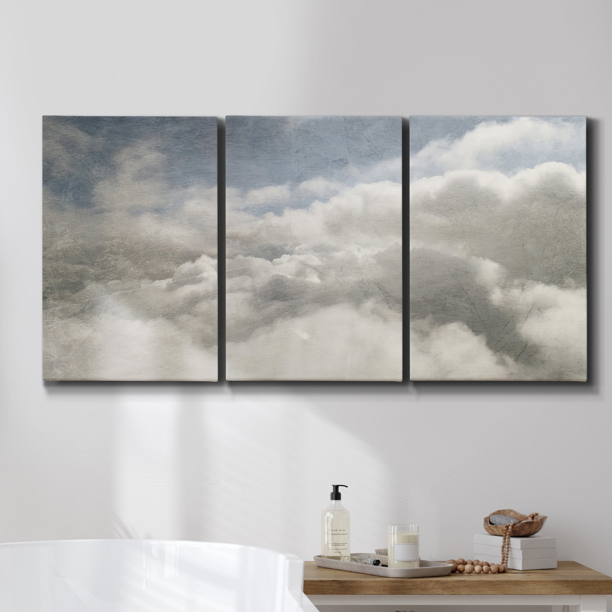 Three-panel canvas wall art featuring aerial landscape view photograph, displayed in a bathroom above a bathtub.
