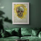 Expressive skull study painting by Vincent van Gogh in an ornate weathered white frame displayed in a dark-toned interior setting.