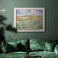 Impressionist countryside landscape near Auvers by Vincent van Gogh in an ornate weathered white frame displayed in a dark-toned interior setting.