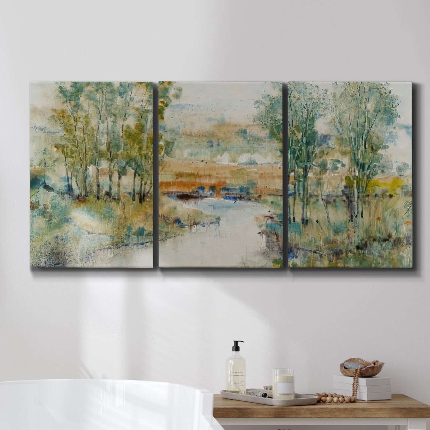 Three-panel canvas wall art featuring trees lining quiet creek, displayed in a bathroom above a bathtub.
