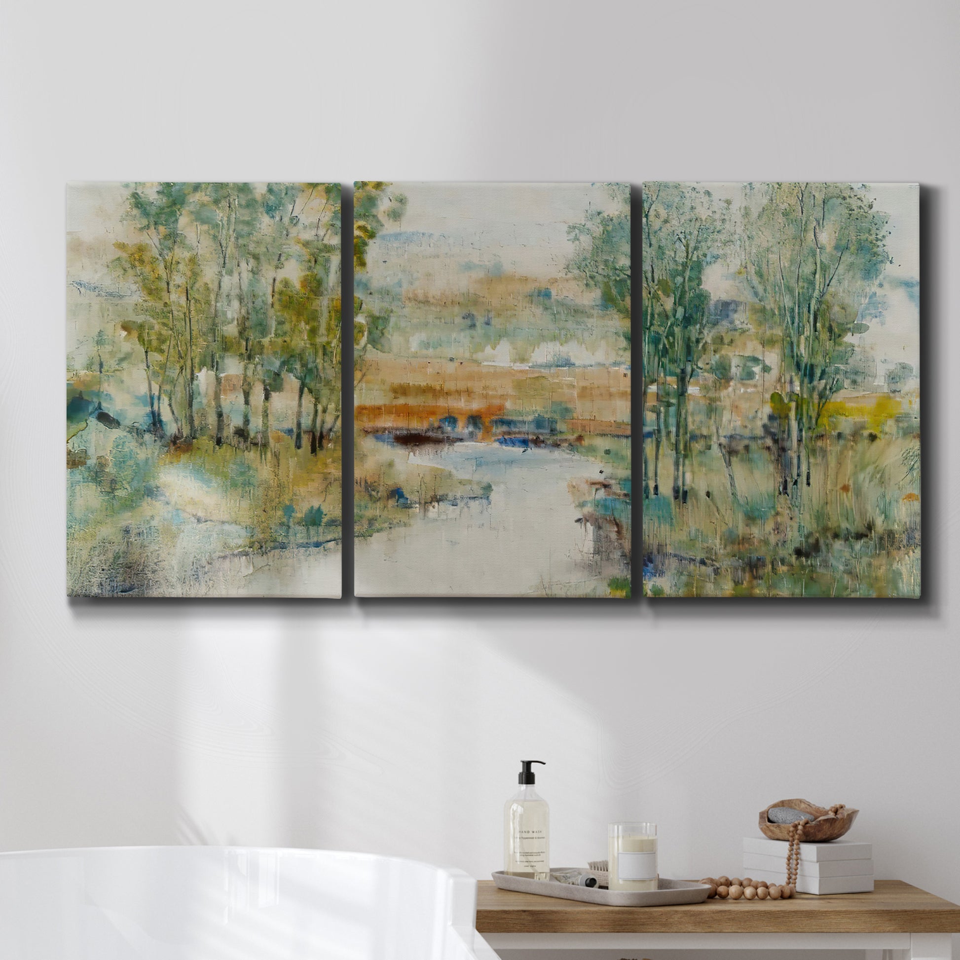 Three-panel canvas wall art featuring trees lining quiet creek, displayed in a bathroom above a bathtub.