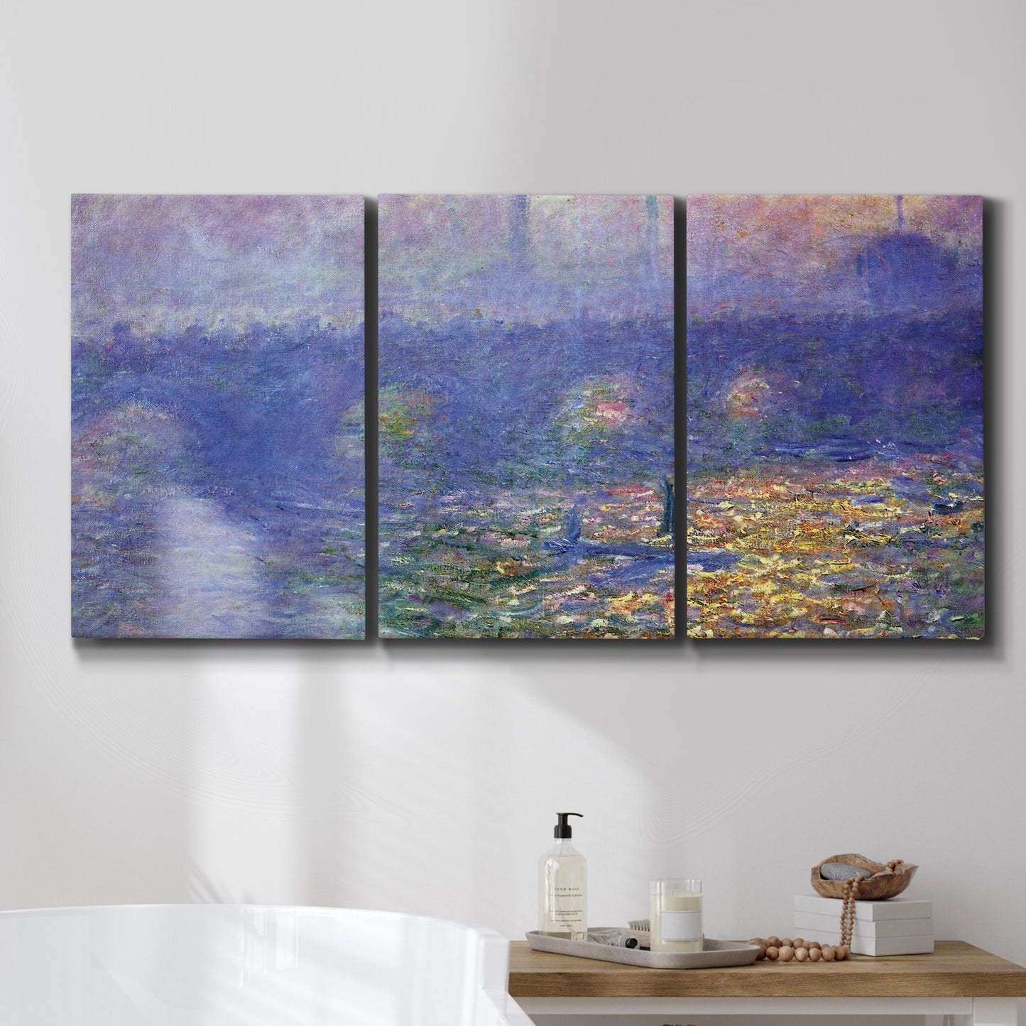 Three-panel canvas wall art featuring overcast bridge above river, displayed in a bathroom above a bathtub.