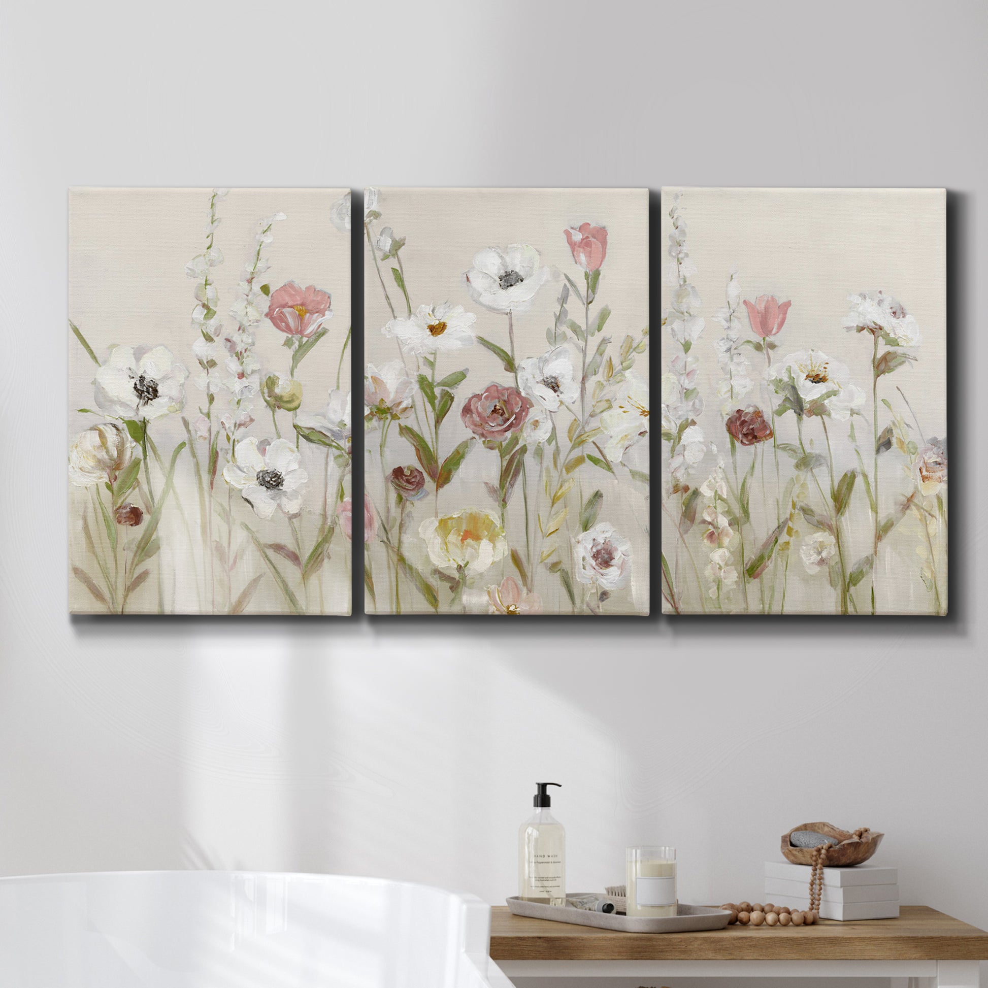 Three-panel canvas wall art featuring loose farmhouse style floral painting, displayed in a bathroom above a bathtub.