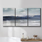 Three-panel canvas wall art featuring abstract coastal tones and movement, displayed in a bathroom above a bathtub.