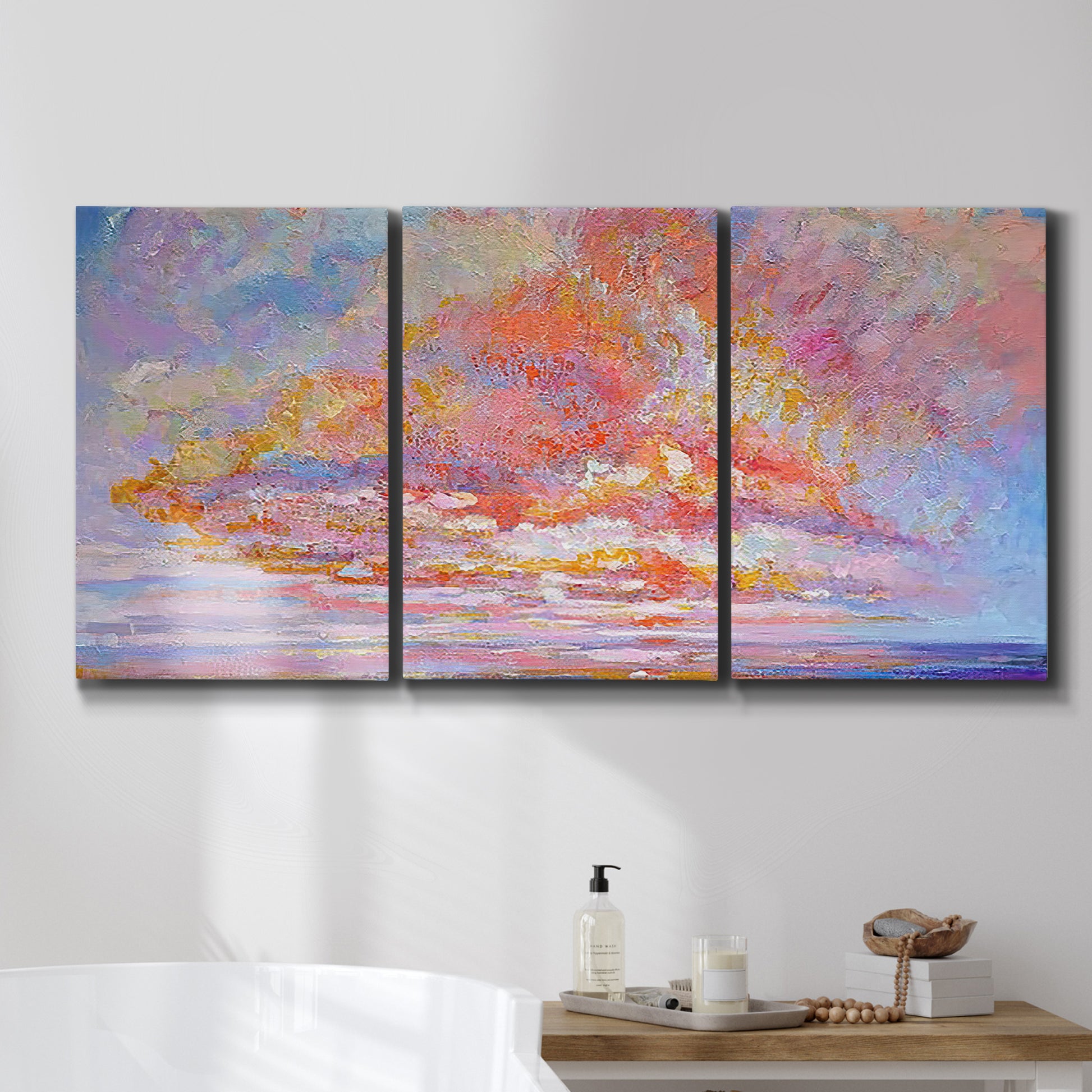 Three-panel canvas wall art featuring peaceful tropical inspired landscape, displayed in a bathroom above a bathtub.