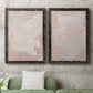 Set of two black barnwood framed canvas prints depicting a coordinated art pair of soft blush and white painterly fields rendered as minimalist color-field abstracts above a sofa in a modern living room.