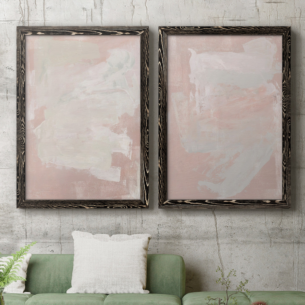 Set of two black barnwood framed canvas prints depicting a coordinated art pair of soft blush and white painterly fields rendered as minimalist color-field abstracts above a sofa in a modern living room.