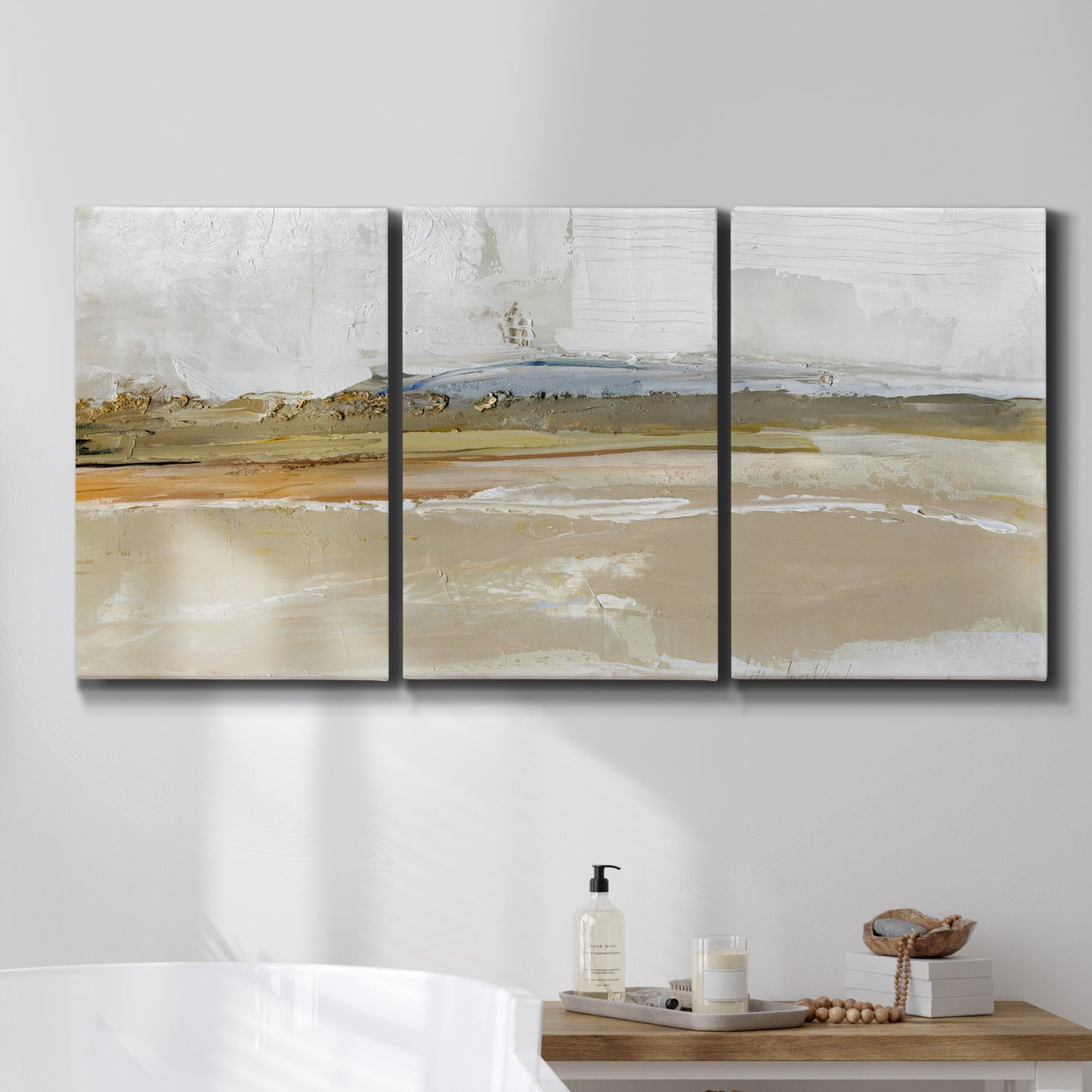 Three-panel canvas wall art featuring golden hour light over landscape, displayed in a bathroom above a bathtub.