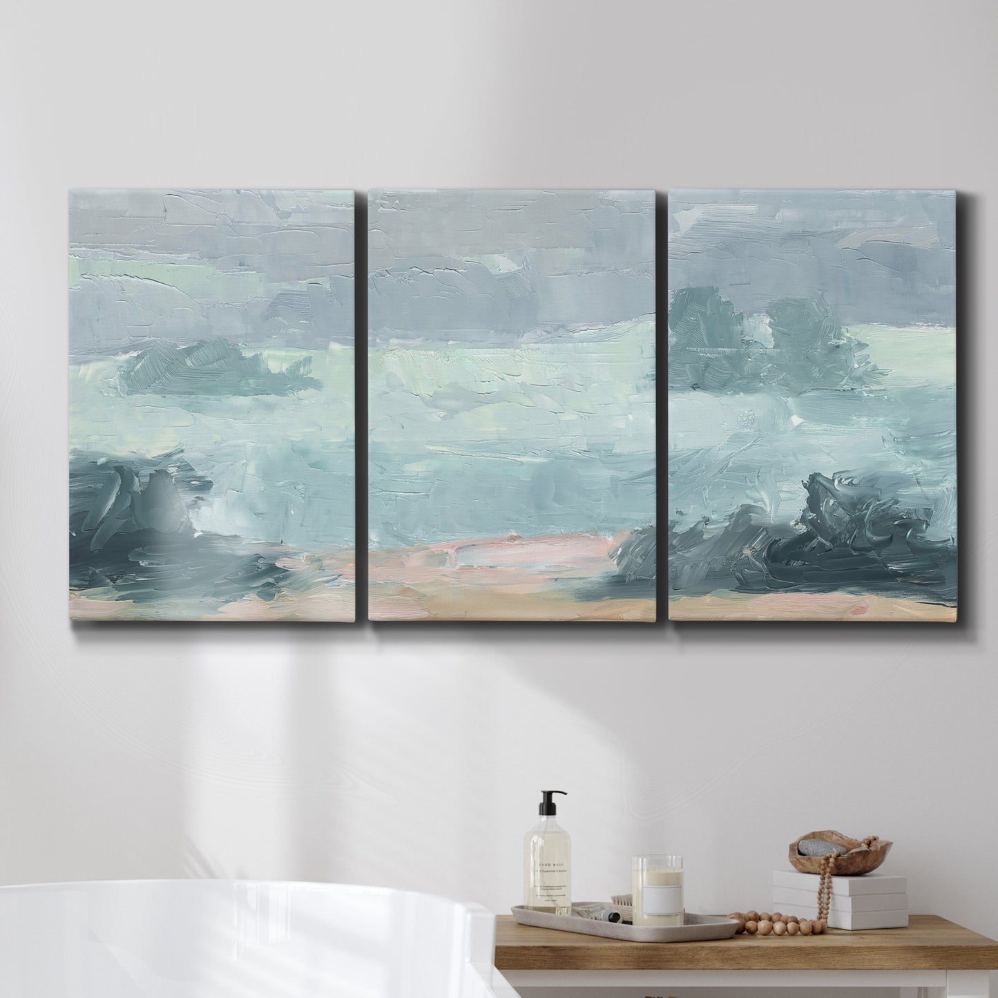 Three-panel canvas wall art featuring soft pastel valley landscape, displayed in a bathroom above a bathtub.