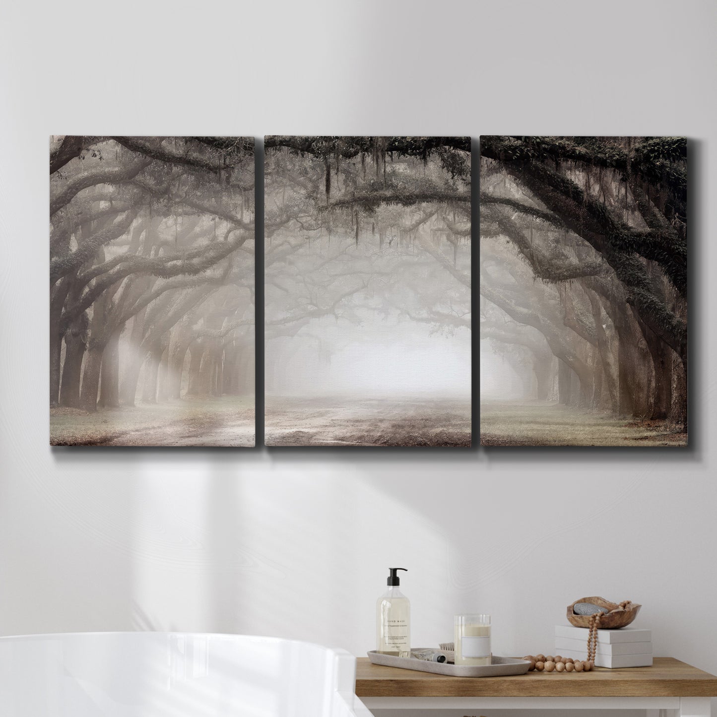 Three-panel canvas wall art featuring tree lined plantation road, displayed in a bathroom above a bathtub.