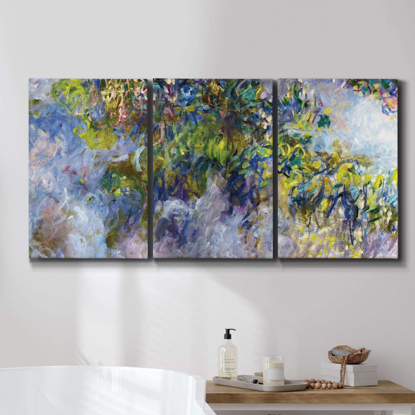 Three-panel canvas wall art featuring cascading purple wisteria blooms, displayed in a bathroom above a bathtub.