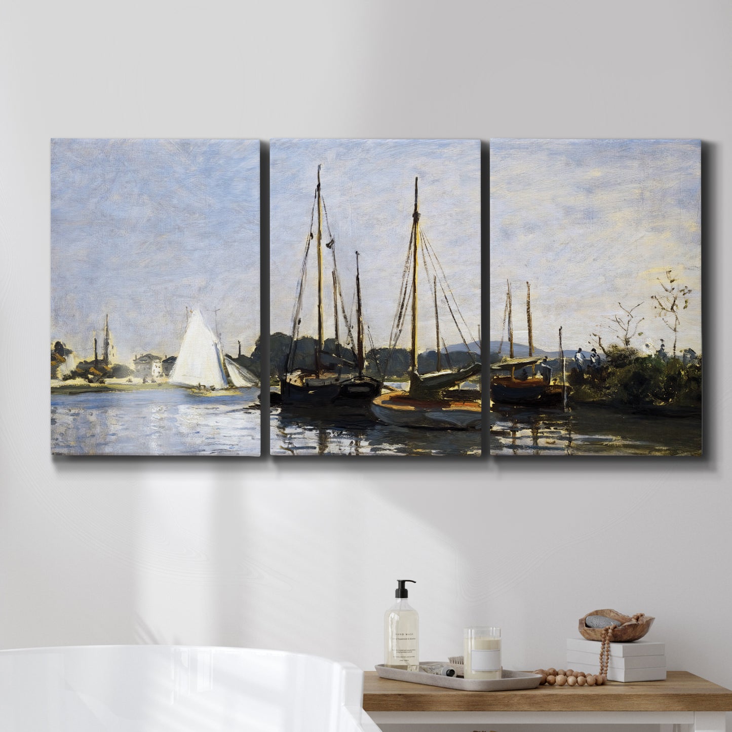 Three-panel canvas wall art featuring small pleasure boats on calm water, displayed in a bathroom above a bathtub.