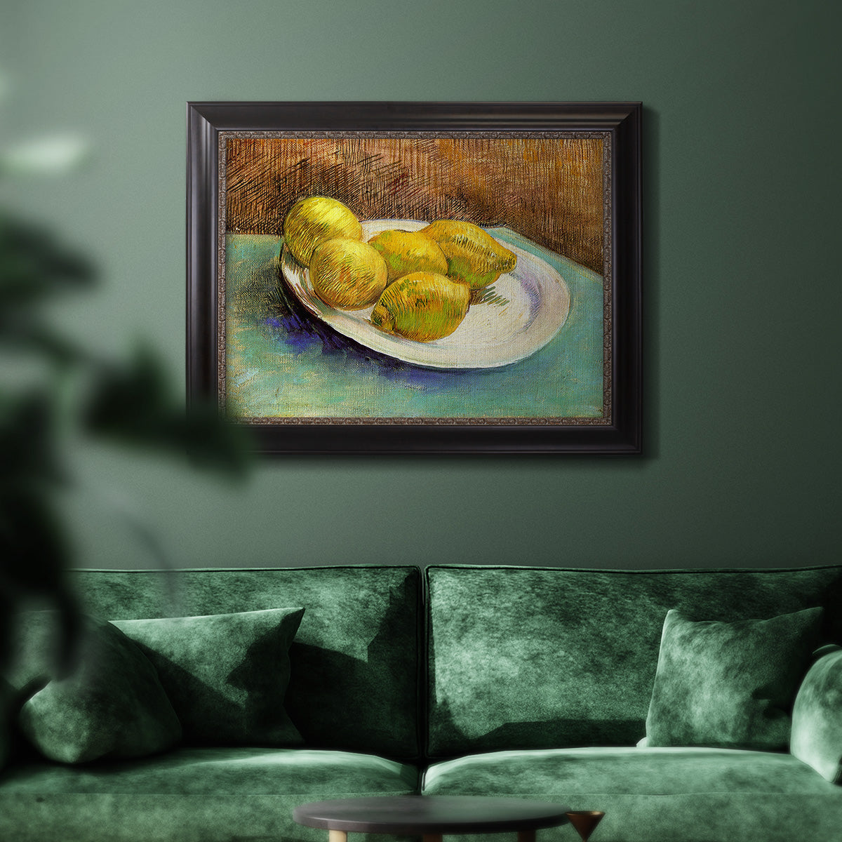 Impressionist still life with lemons by Vincent van Gogh in an ornate black frame with gilded inner detail displayed in a dark-toned interior setting.