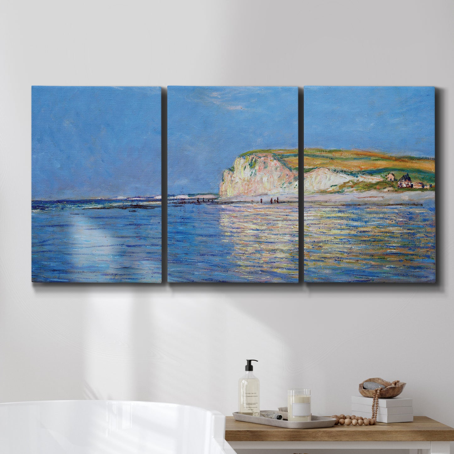 Three-panel canvas wall art featuring white cliffs rising above sea, displayed in a bathroom above a bathtub.
