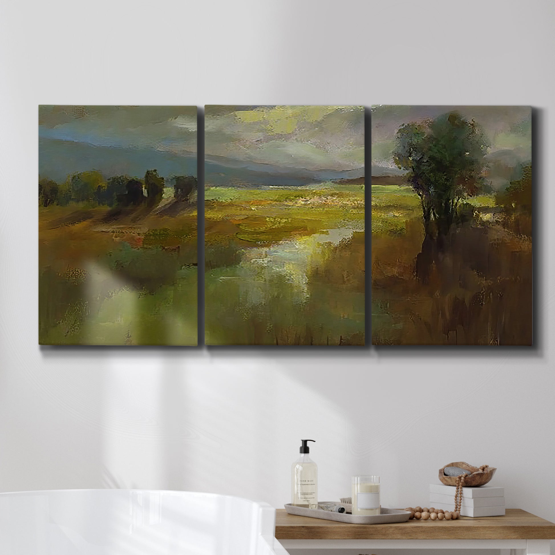 Three-panel canvas wall art featuring winding rural road through countryside, displayed in a bathroom above a bathtub.