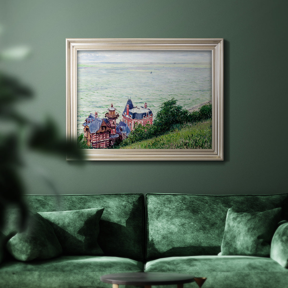 Impressionist coastal villas landscape by Gustave Caillebotte in an ornate champagne frame displayed in a dark-toned interior setting.