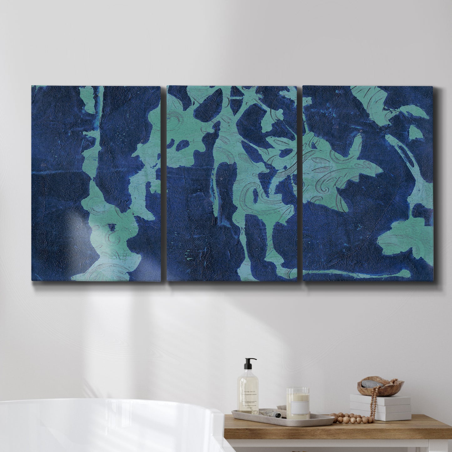 Three-panel canvas wall art featuring abstract floral shapes, displayed in a bathroom above a bathtub.