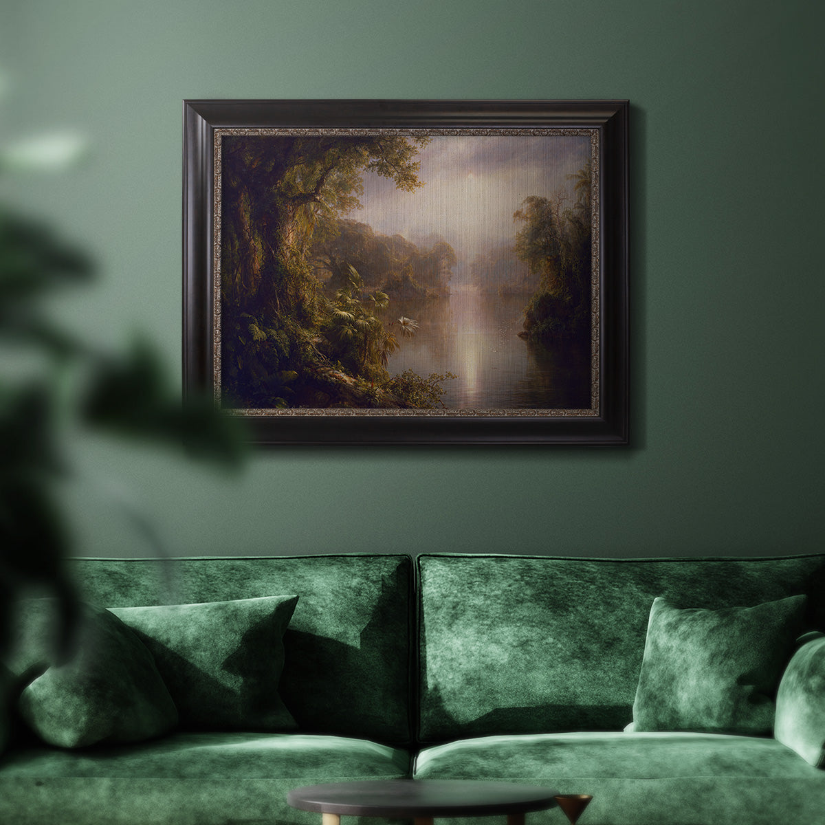 Luminous romantic landscape painting by Frederic Edwin Church in an ornate black frame with gilded inner detail displayed in a dark-toned interior setting.