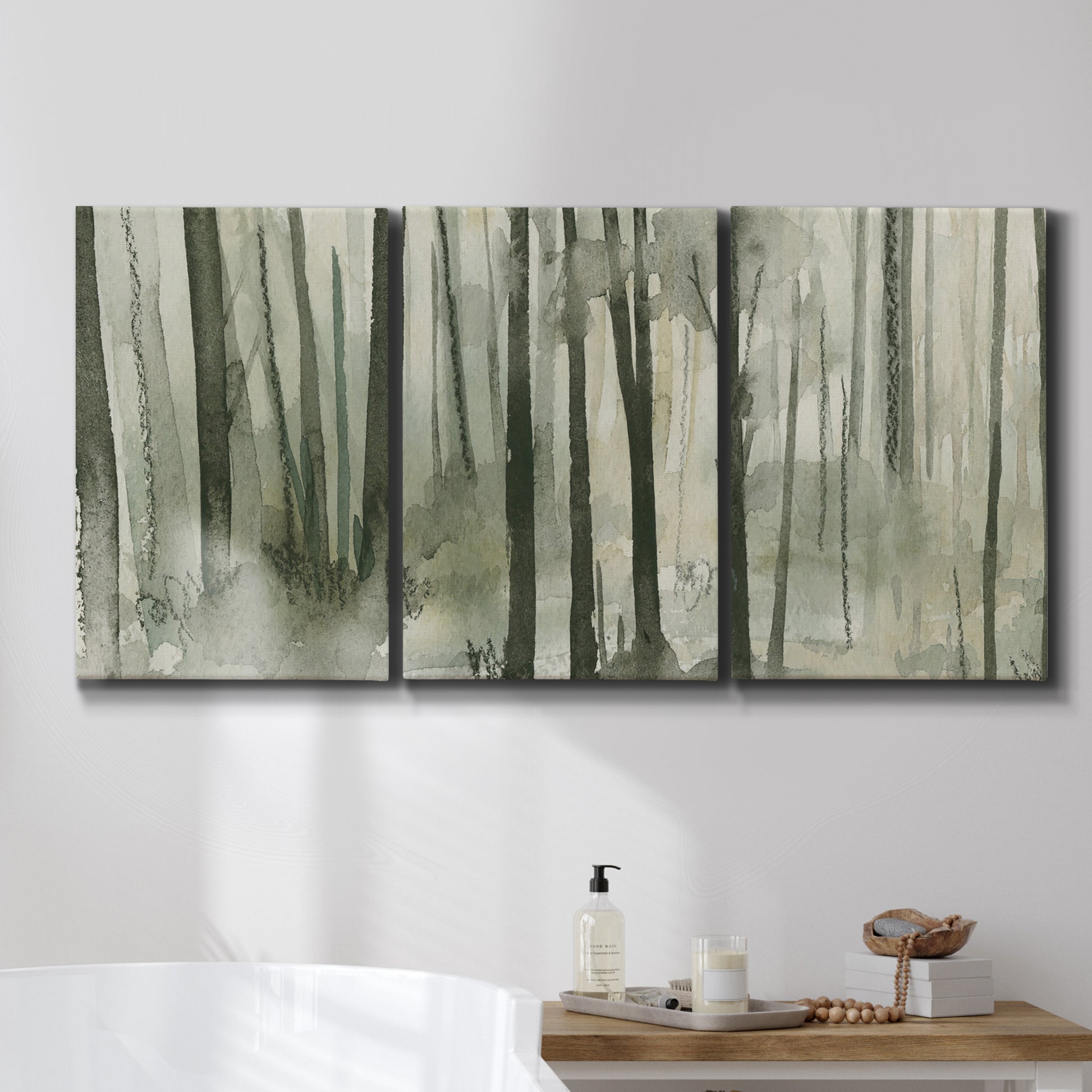 Three-panel canvas wall art featuring wooded forest path watercolor, displayed in a bathroom above a bathtub.