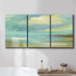 Three-panel canvas wall art featuring calm coastal drift patterns, displayed in a bathroom above a bathtub.