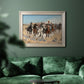 Impressionist western action scene by Frederic Remington in an ornate champagne frame displayed in a dark-toned interior setting.