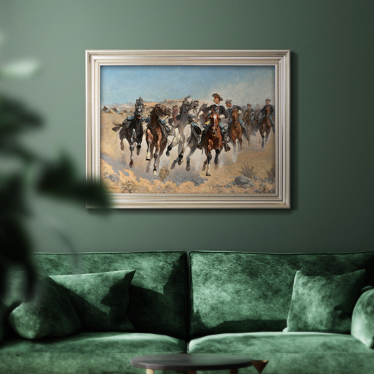Impressionist western action scene by Frederic Remington in an ornate champagne frame displayed in a dark-toned interior setting.