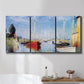 Three-panel canvas wall art featuring sailboats gathered along river, displayed in a bathroom above a bathtub.