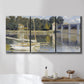 Three-panel canvas wall art featuring bridge crossing broad river, displayed in a bathroom above a bathtub.