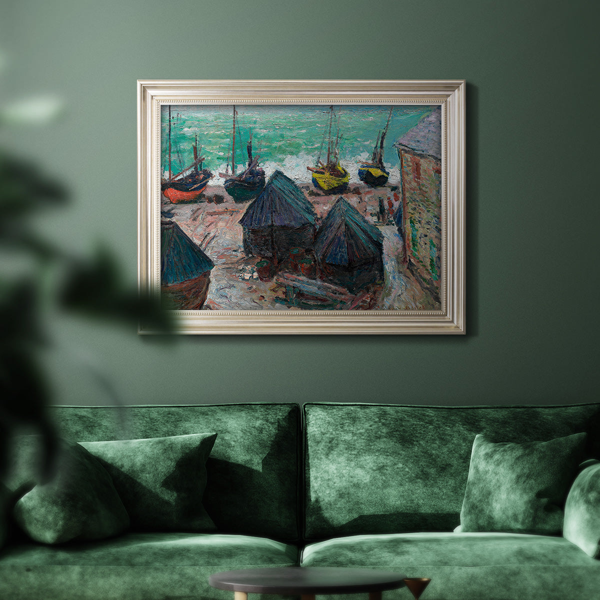Impressionist coastal beach scene with boats by Claude Monet in an ornate champagne frame displayed in a dark-toned interior setting.