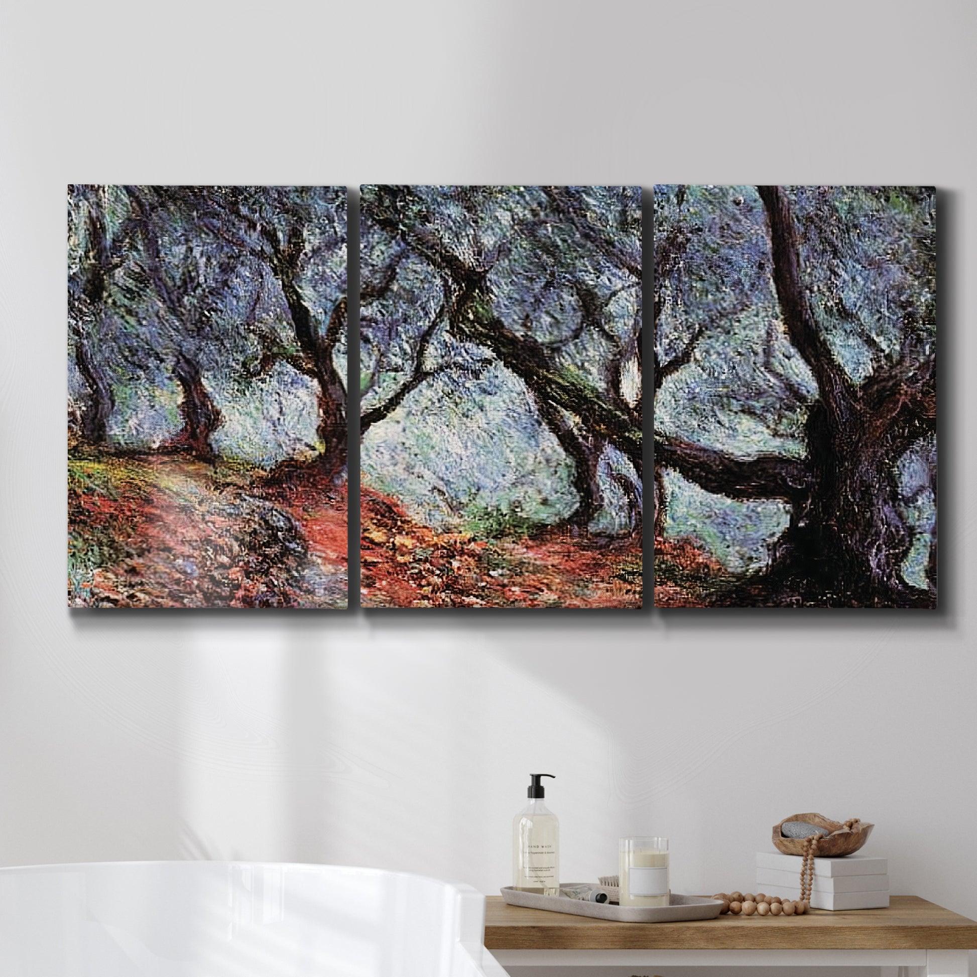 Three-panel canvas wall art featuring pine trees silhouetted at evening, displayed in a bathroom above a bathtub.