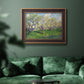 Impressionist spring orchard landscape by Vincent van Gogh in an ornate bronzed mahogany wood frame displayed in a dark-toned interior setting.