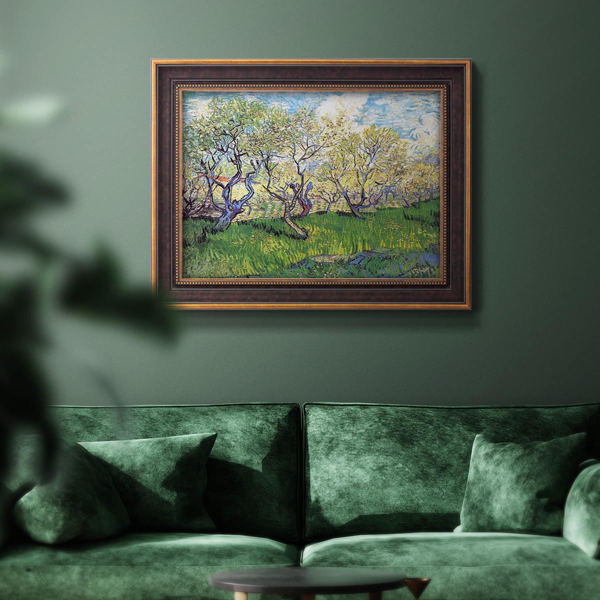 Impressionist spring orchard landscape by Vincent van Gogh in an ornate bronzed mahogany wood frame displayed in a dark-toned interior setting.