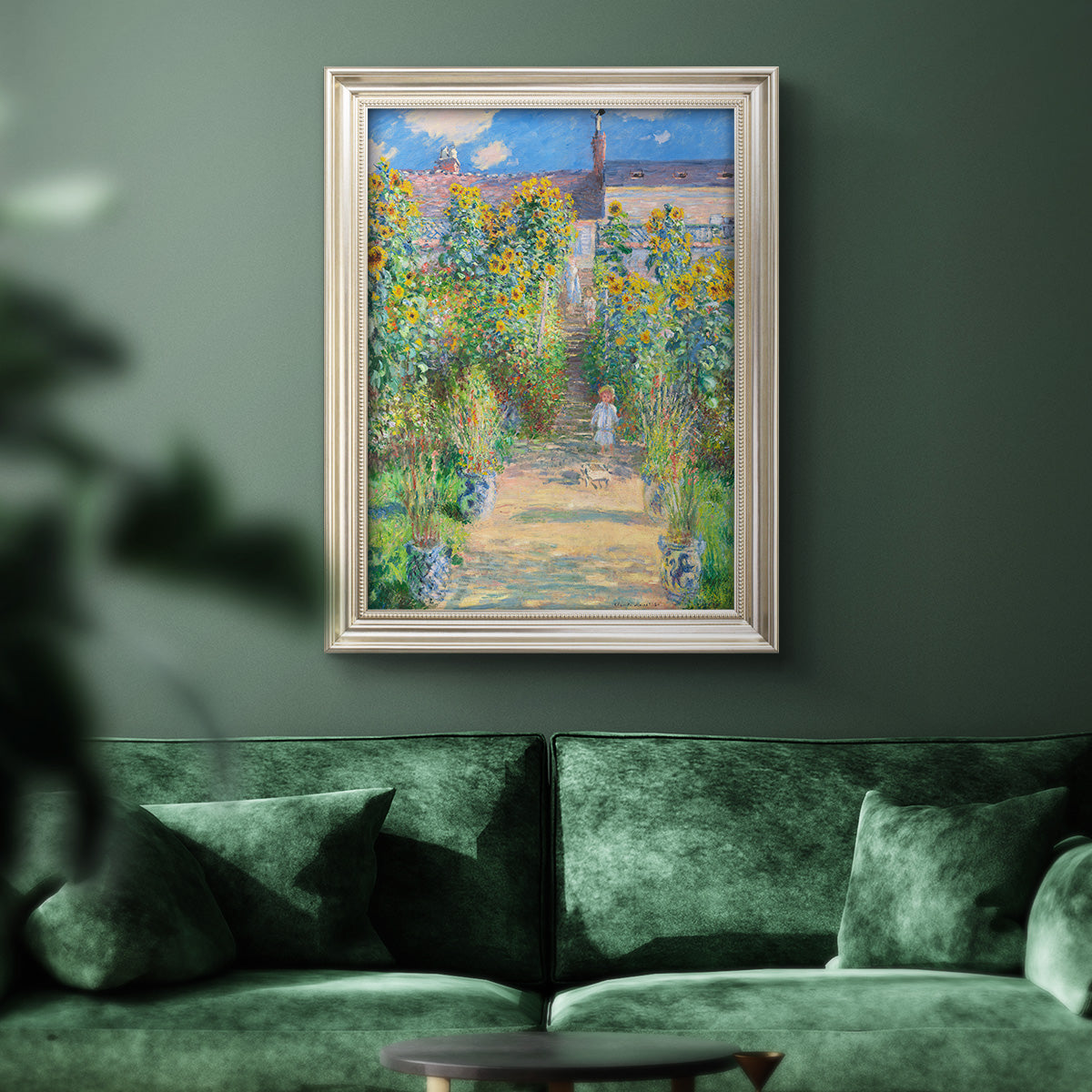 Impressionist garden landscape painting by Claude Monet in an ornate champagne frame displayed in a dark-toned interior setting.
