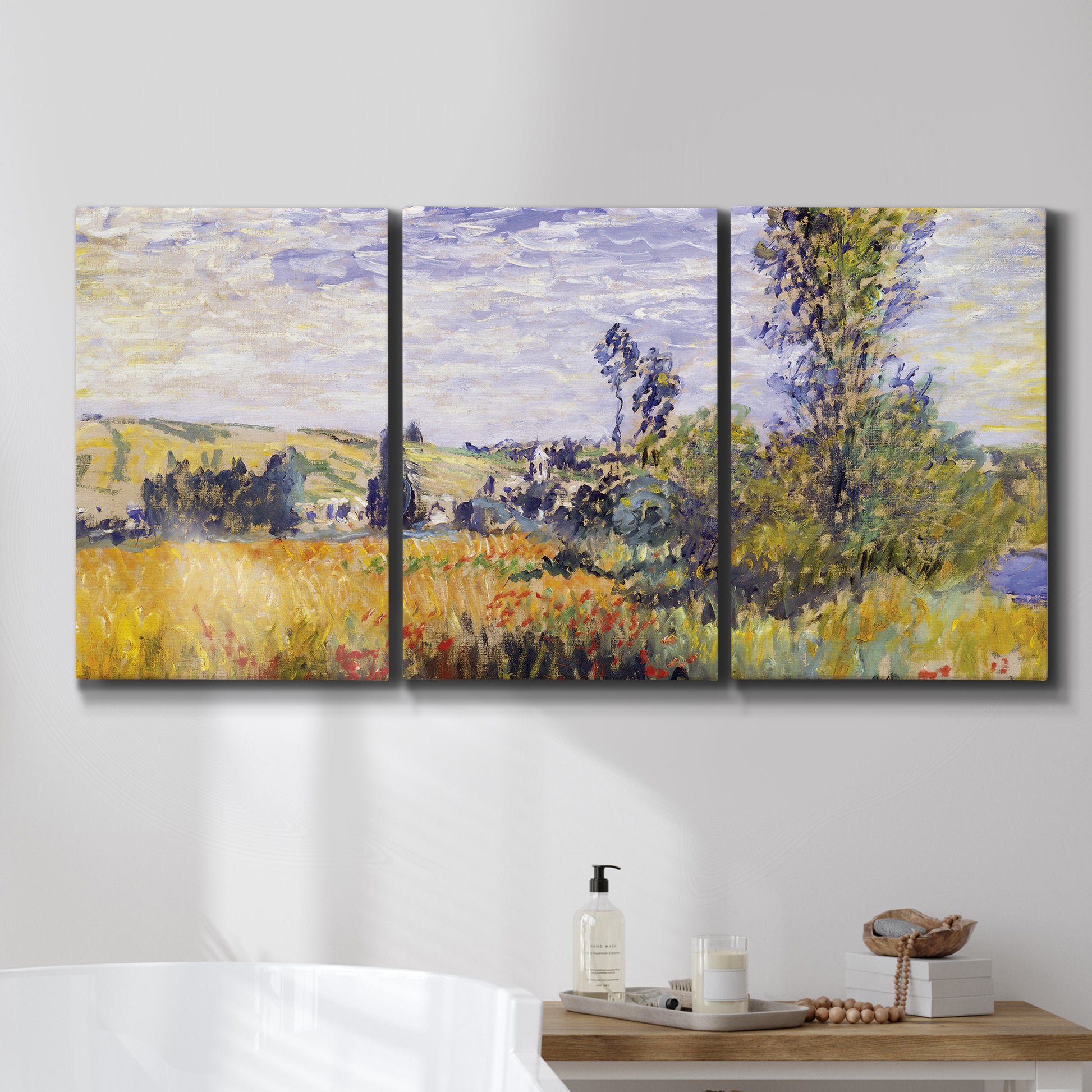 Three-panel canvas wall art featuring river village landscape with hills, displayed in a bathroom above a bathtub.