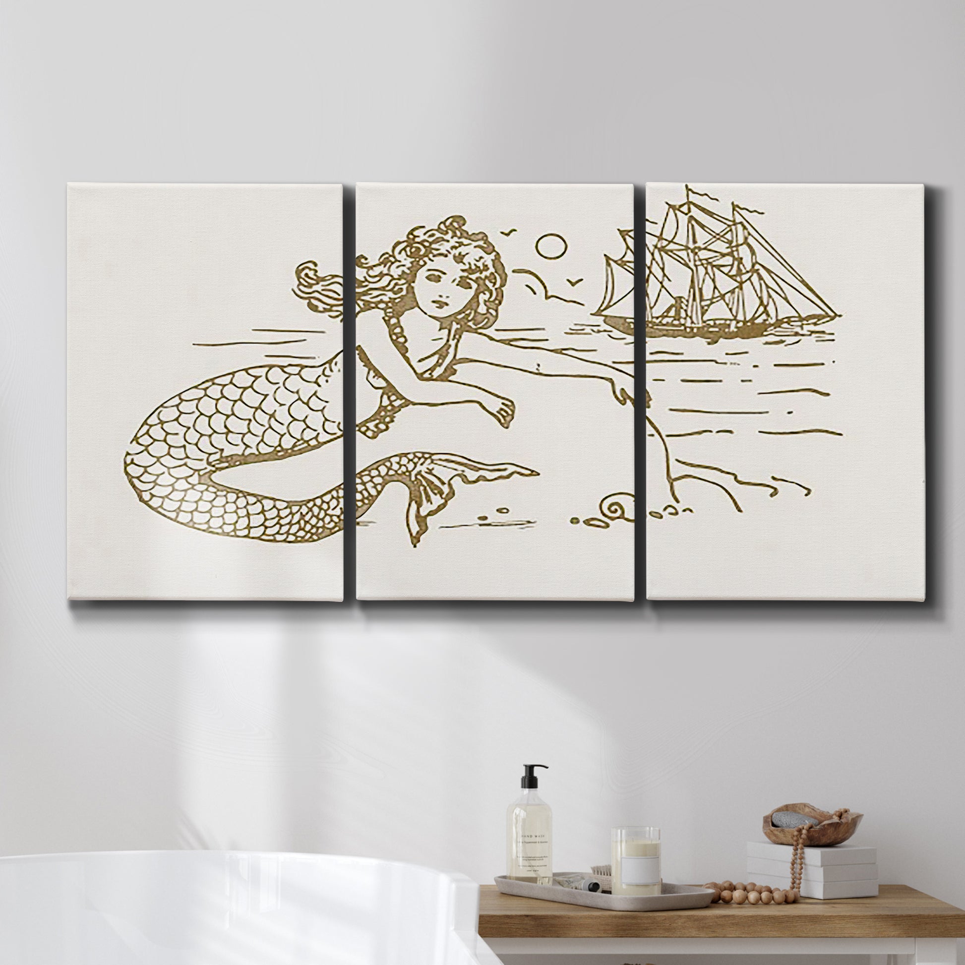 Three-panel canvas wall art featuring whimsical mermaid resting by sea, displayed in a bathroom above a bathtub.