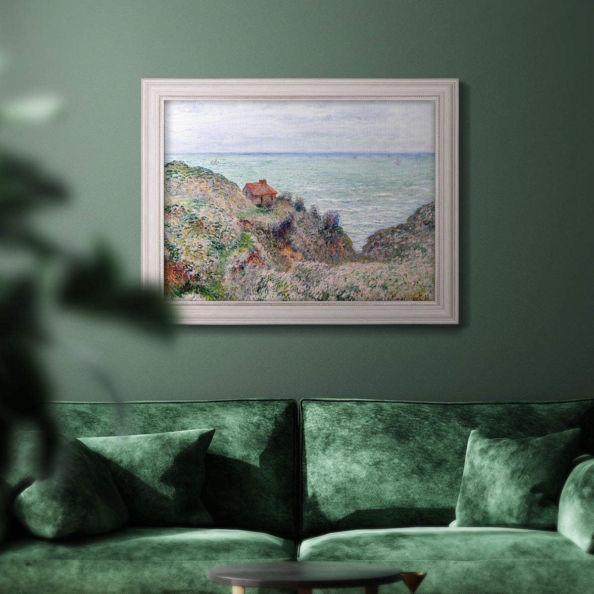 Impressionist coastal watch cabin scene by Claude Monet in an ornate weathered white frame displayed in a dark-toned interior setting.
