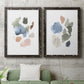 Set of two black barnwood framed canvas prints depicting a coordinated art pair of scattered translucent watercolor shapes rendered as airy minimalist abstracts above a sofa in a modern living room.