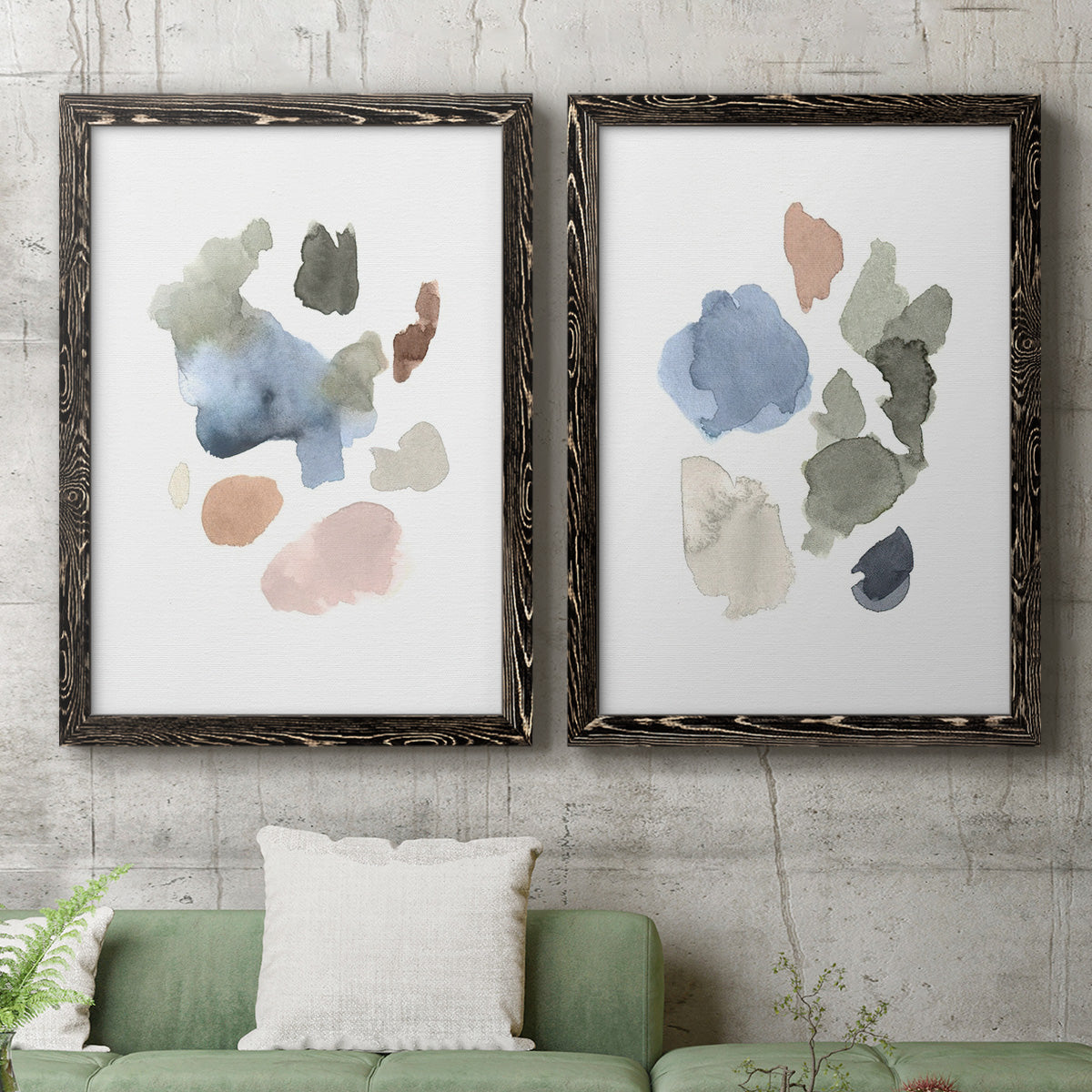 Set of two black barnwood framed canvas prints depicting a coordinated art pair of scattered translucent watercolor shapes rendered as airy minimalist abstracts above a sofa in a modern living room.