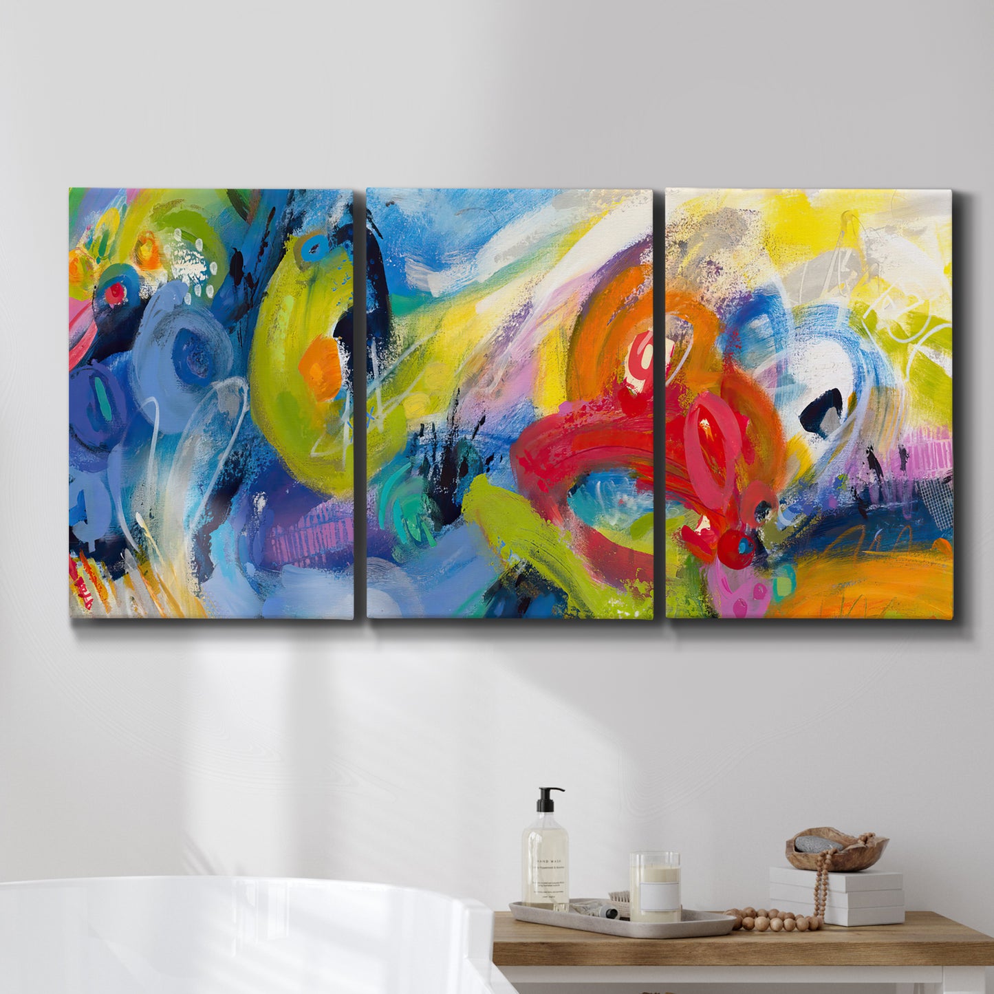 Three-panel canvas wall art featuring colorful abstract racing forms, displayed in a bathroom above a bathtub.