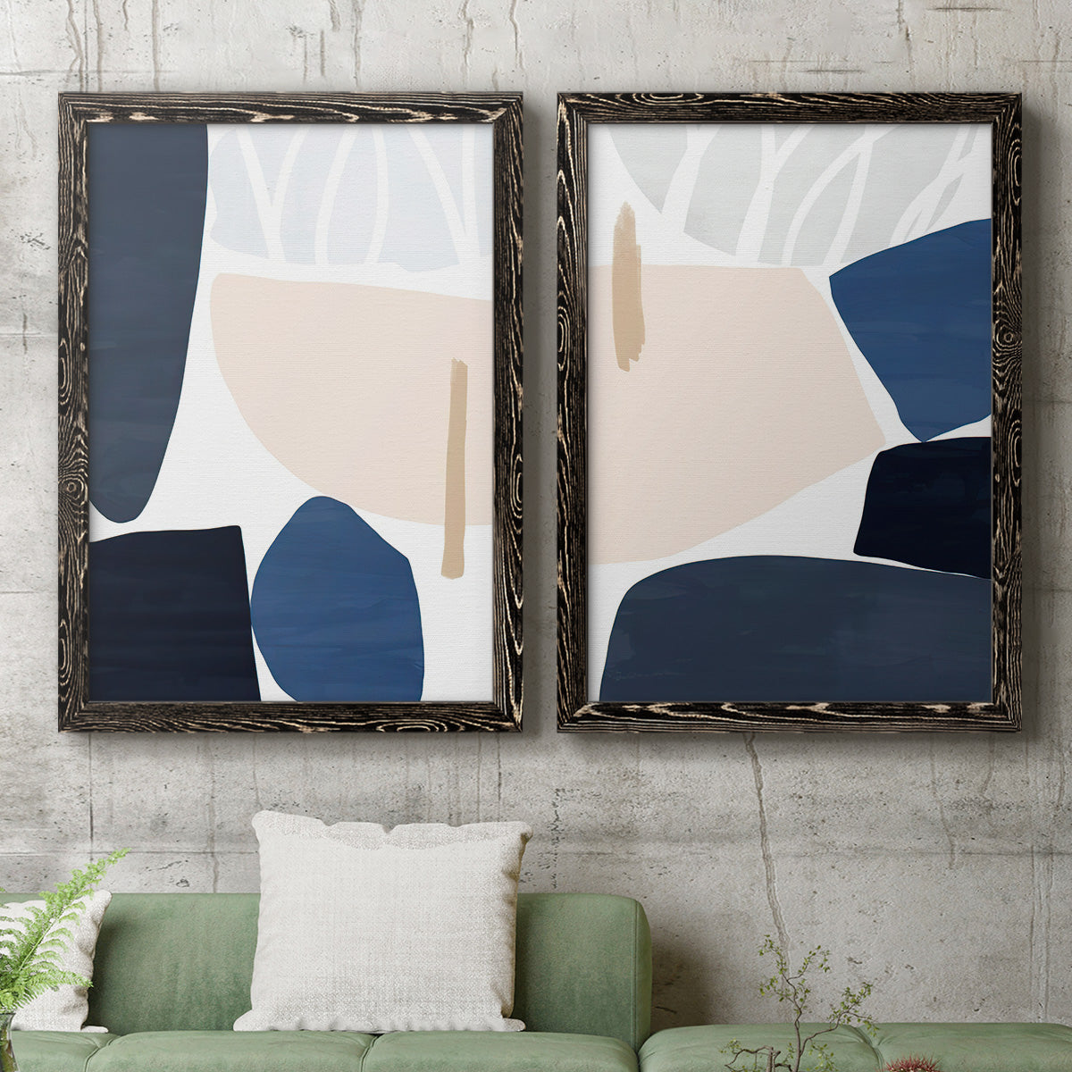 Set of two black barnwood framed canvas prints depicting a coordinated art pair of large navy cream and beige organic geometric shapes rendered as minimalist color-block abstracts above a sofa in a modern living room.