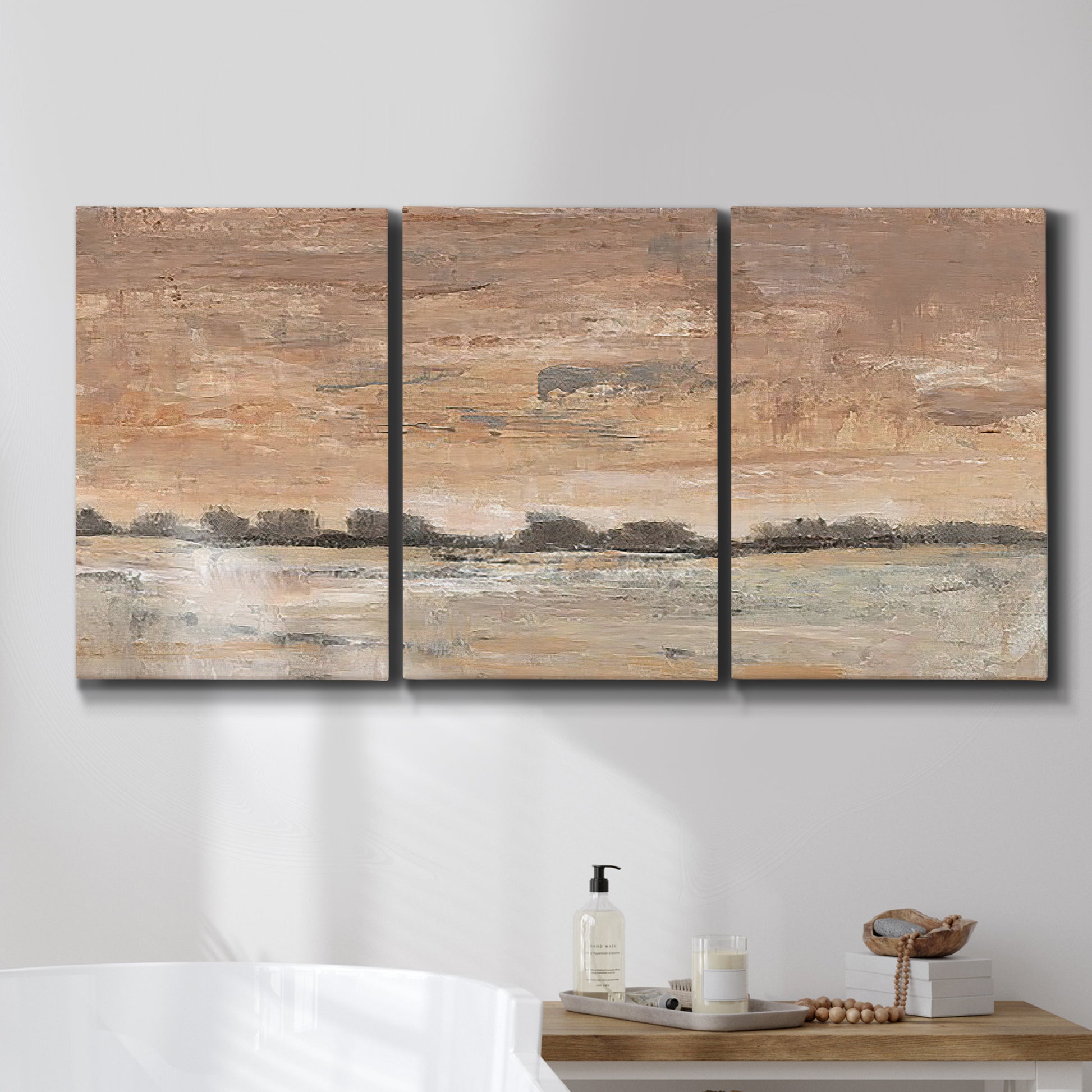 Three-panel canvas wall art featuring soft early evening landscape light, displayed in a bathroom above a bathtub.