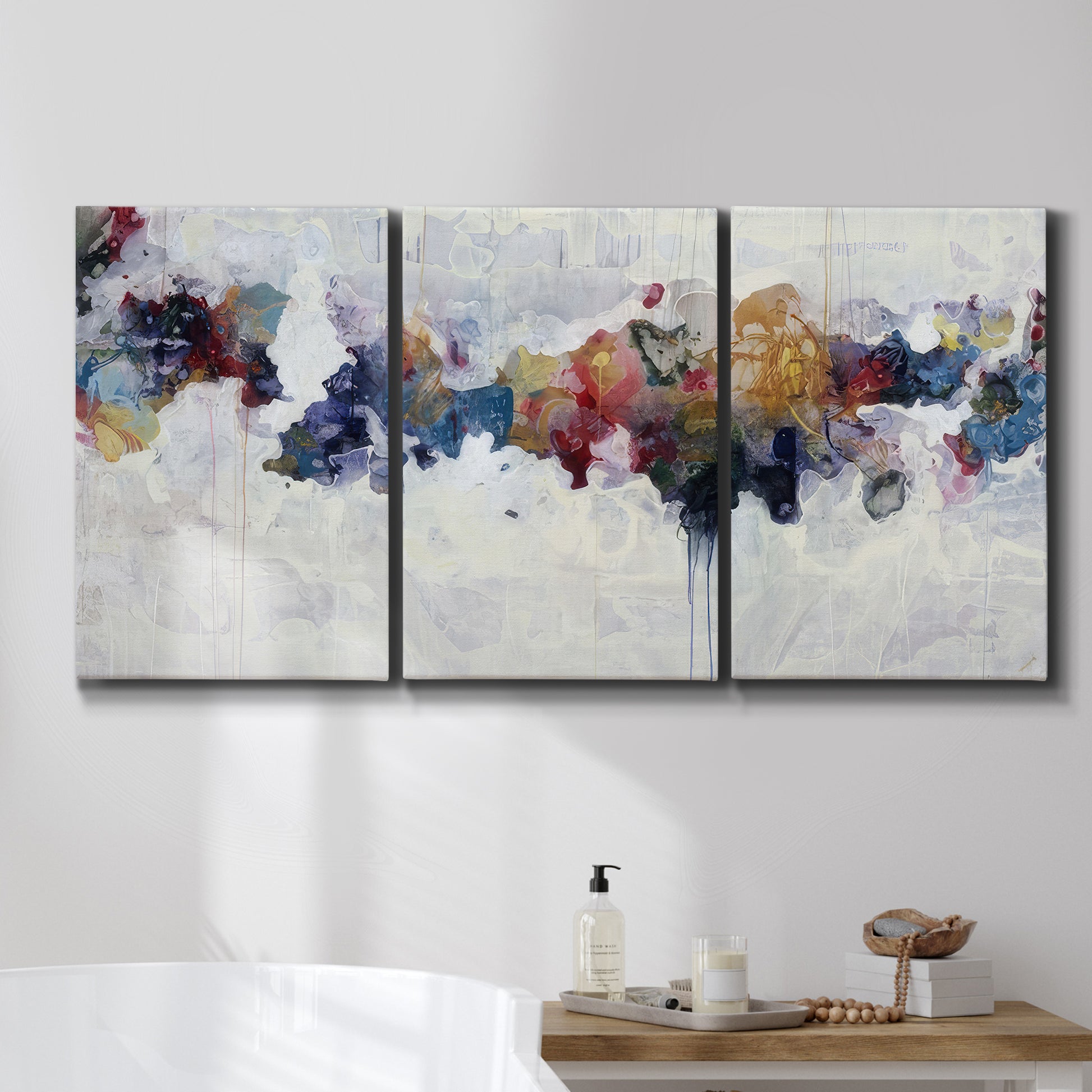 Three-panel canvas wall art featuring abstract water inspired composition, displayed in a bathroom above a bathtub.