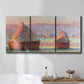 Three-panel canvas wall art featuring winter grainstacks glowing at sunset, displayed in a bathroom above a bathtub.